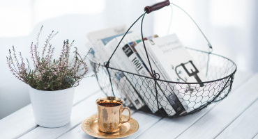 panier avec des livres, une tasse de café et une plante